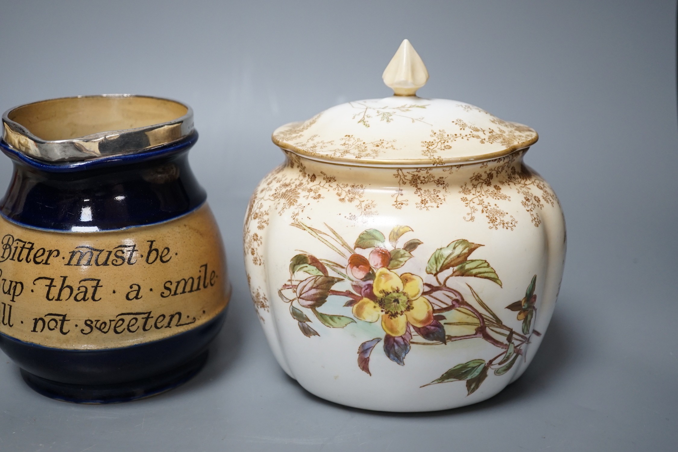 A late 19th / Early 20th century Doulton two handled vase and a Doulton vase and cover both painted with flowers on a blush ivory ground, Doulton Burslem England mark together with a Royal Doulton jug with silver mount a